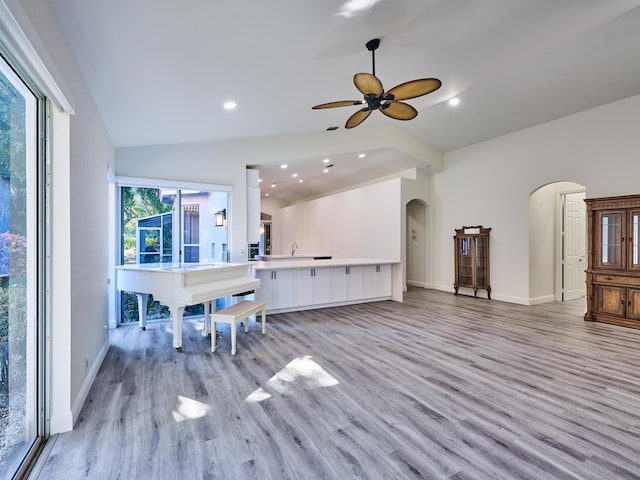 living room with ceiling fan, light hardwood / wood-style floors, a healthy amount of sunlight, and lofted ceiling