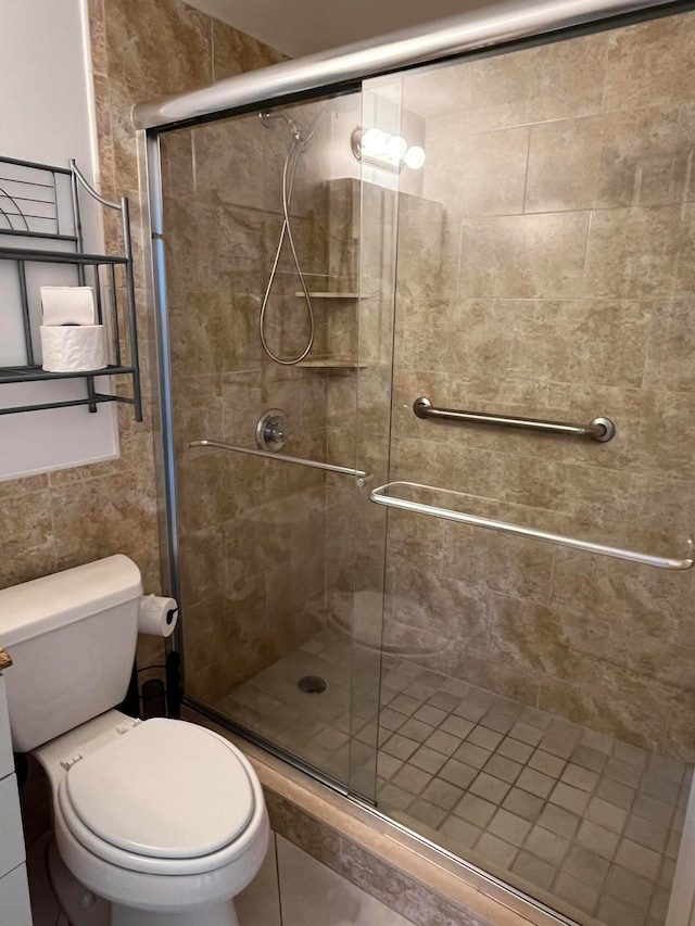 bathroom featuring toilet and an enclosed shower