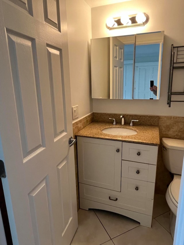 bathroom with tile patterned flooring, vanity, and toilet