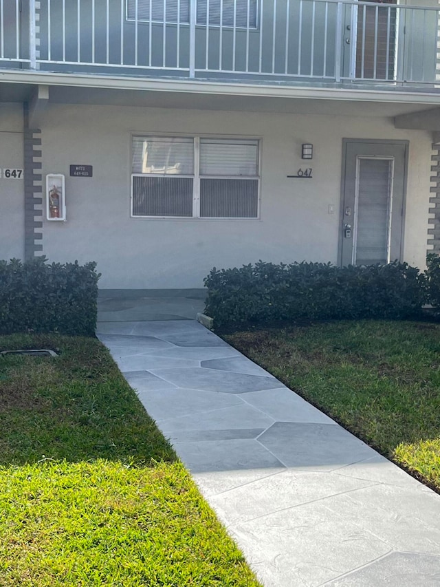 view of exterior entry with a lawn