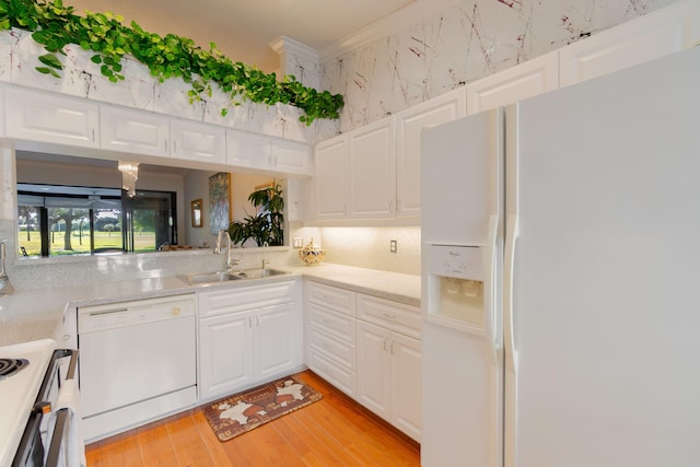 kitchen with white cabinets, white appliances, light hardwood / wood-style flooring, and sink