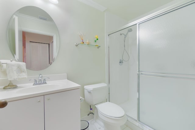 bathroom featuring tile patterned floors, toilet, a shower with door, vanity, and ornamental molding