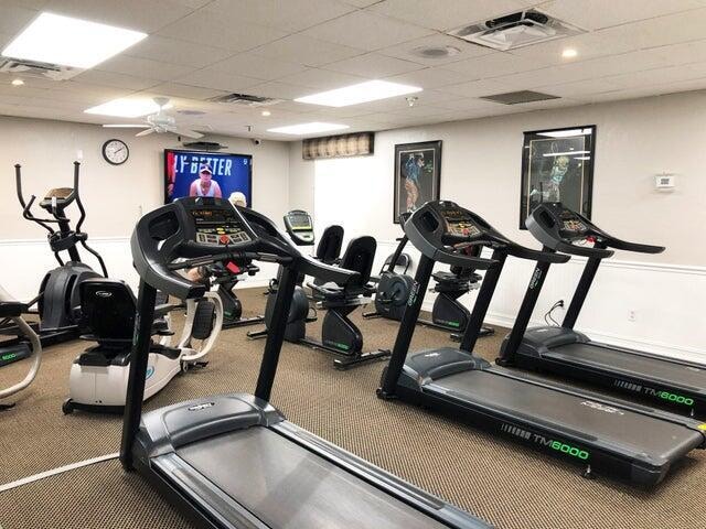 gym featuring ceiling fan and a drop ceiling