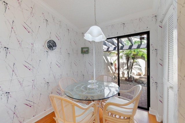 dining area featuring light hardwood / wood-style flooring and ornamental molding