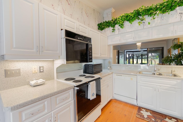 kitchen featuring light hardwood / wood-style floors, white cabinetry, white appliances, and sink