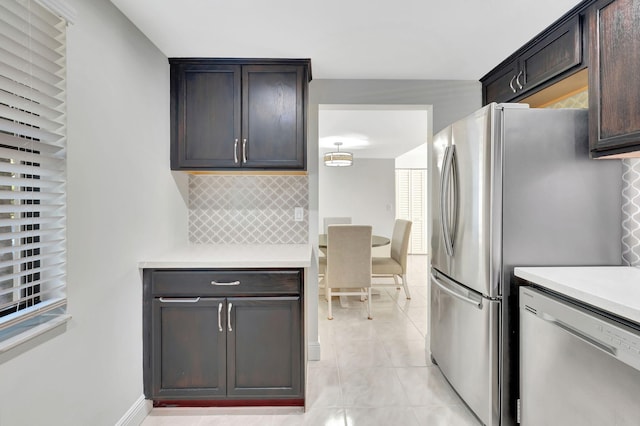 kitchen featuring dark brown cabinets, backsplash, and appliances with stainless steel finishes