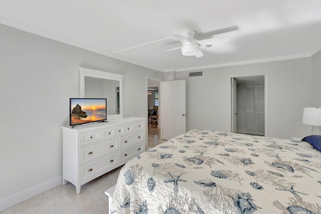 bedroom with ceiling fan, a closet, light tile patterned flooring, and ornamental molding