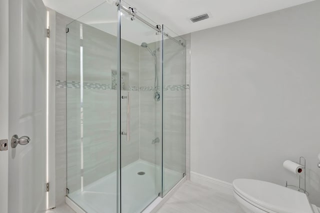 bathroom featuring walk in shower and toilet