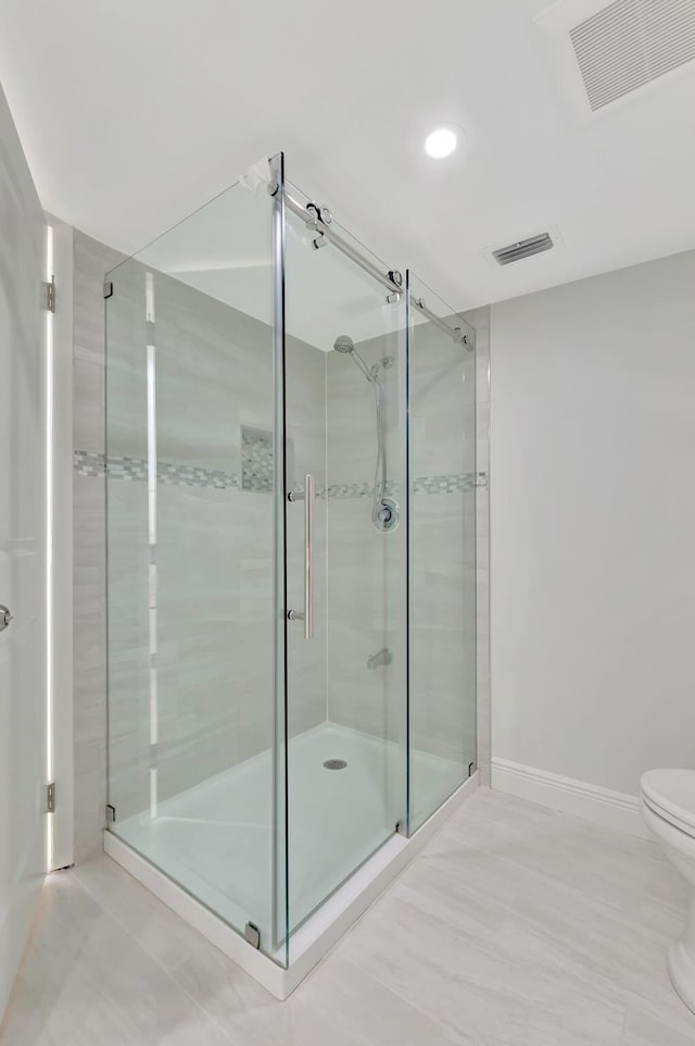 bathroom with toilet and a shower with shower door