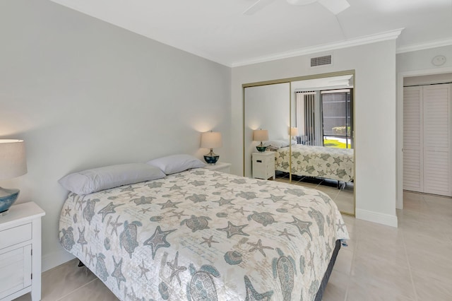 bedroom with light tile patterned floors, a closet, ceiling fan, and crown molding