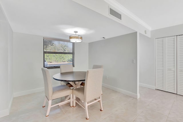 dining space with crown molding and light tile patterned floors