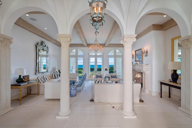 interior space featuring a high end fireplace, beam ceiling, light tile patterned floors, and an inviting chandelier