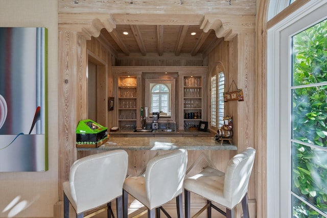 bar with beam ceiling, stone counters, plenty of natural light, and wood ceiling