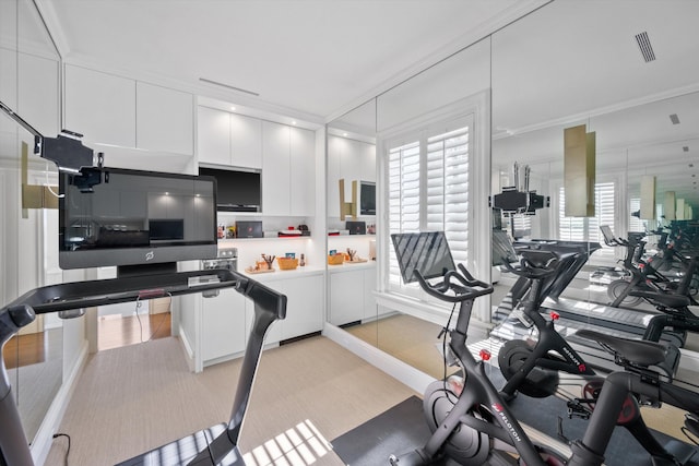 workout area with light colored carpet and crown molding