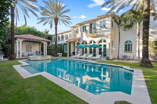 view of swimming pool featuring a lawn, an in ground hot tub, and a patio