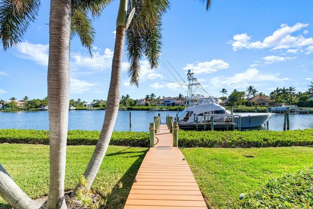 view of dock with a yard and a water view