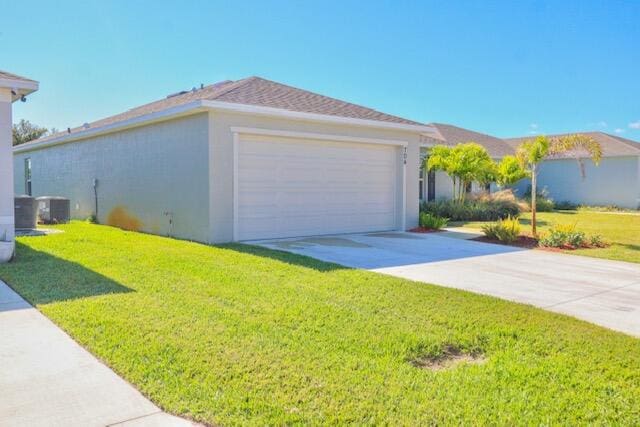 exterior space featuring central AC, a yard, and a garage