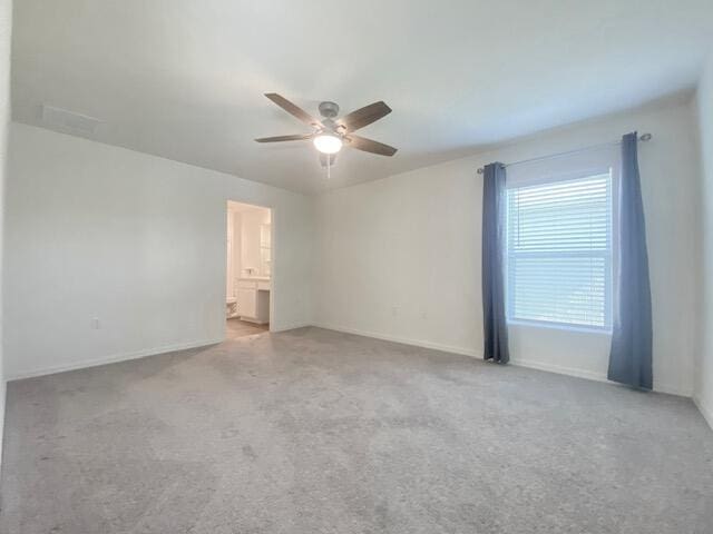 spare room with ceiling fan and light colored carpet