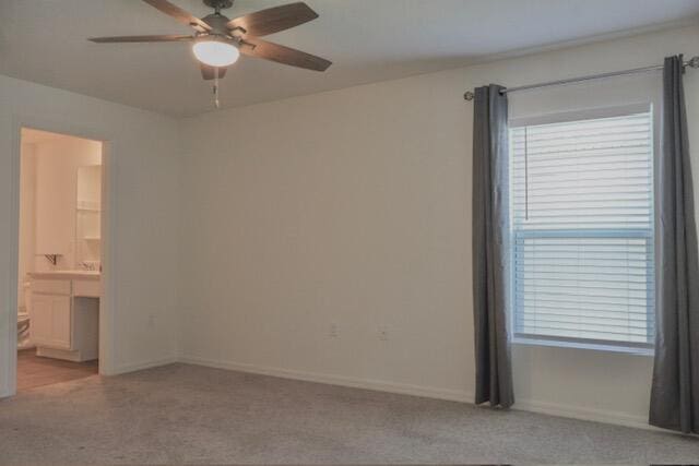 unfurnished room with a wealth of natural light, ceiling fan, and light colored carpet