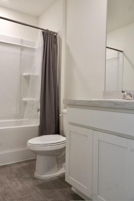 full bathroom featuring hardwood / wood-style flooring, shower / bath combo, toilet, and vanity