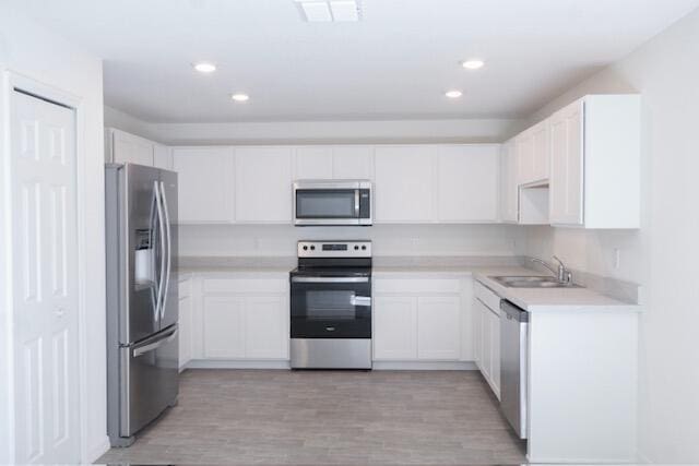 kitchen featuring white cabinets, light hardwood / wood-style floors, sink, and stainless steel appliances