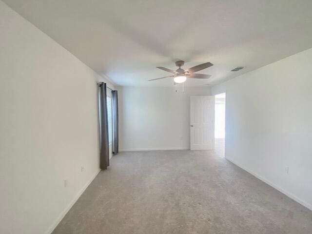 spare room with ceiling fan and light colored carpet