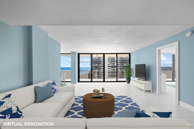 living room featuring a wall of windows, a healthy amount of sunlight, a textured ceiling, and light tile patterned flooring