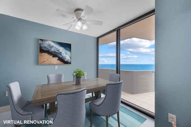 dining area with a ceiling fan and a water view