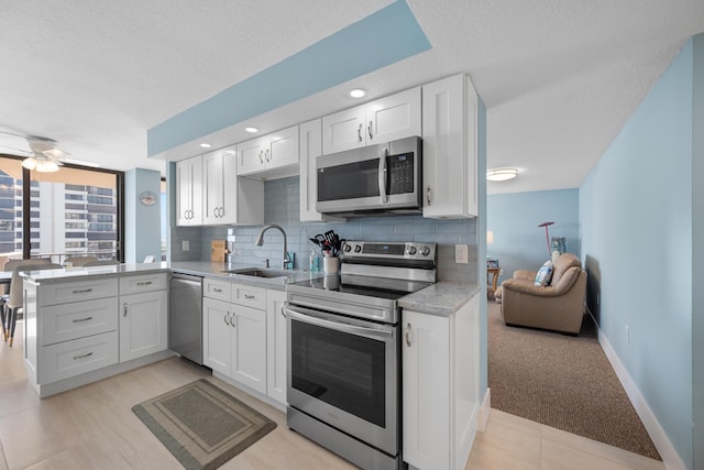 kitchen featuring white cabinetry, sink, a textured ceiling, and appliances with stainless steel finishes