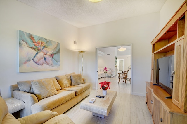 living room featuring light hardwood / wood-style flooring and a textured ceiling