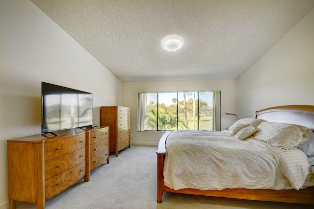 bedroom featuring a textured ceiling, light carpet, and lofted ceiling