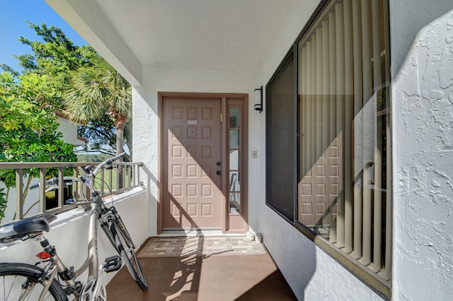 view of exterior entry with a balcony