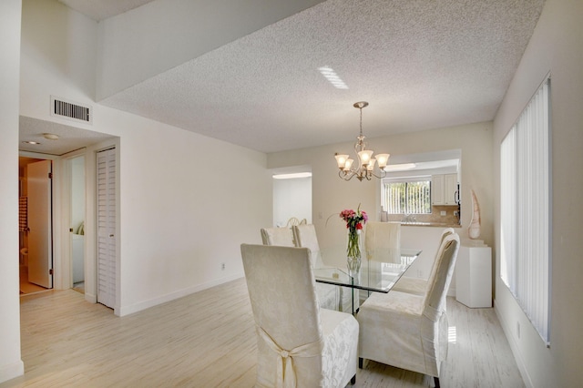 7230 Clunie Pl Unit 15403, Delray Beach, FL 33446 - dining room with a chandelier, light wood-type flooring, a textured ceiling, and baseboards