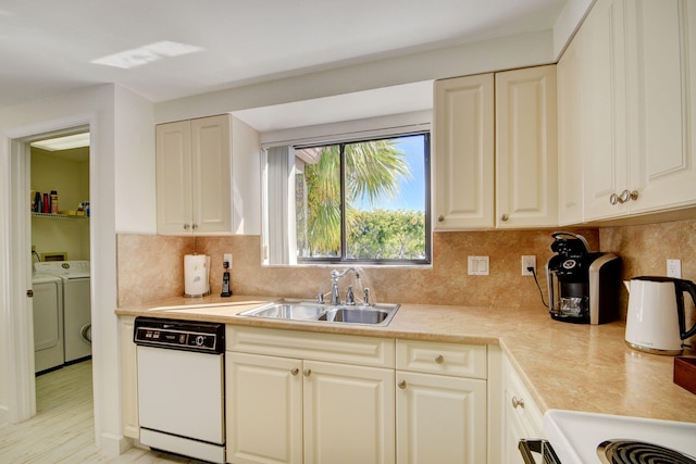 kitchen featuring dishwasher, sink, tasteful backsplash, light hardwood / wood-style floors, and washer and dryer