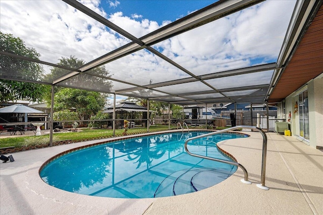 view of pool with glass enclosure and a patio area