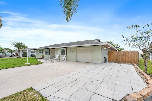 ranch-style house featuring a garage and a front lawn