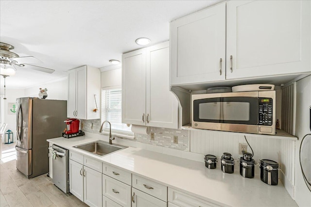 kitchen with stainless steel appliances, white cabinetry, and sink