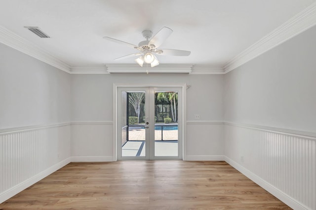 empty room with french doors, light hardwood / wood-style flooring, and crown molding