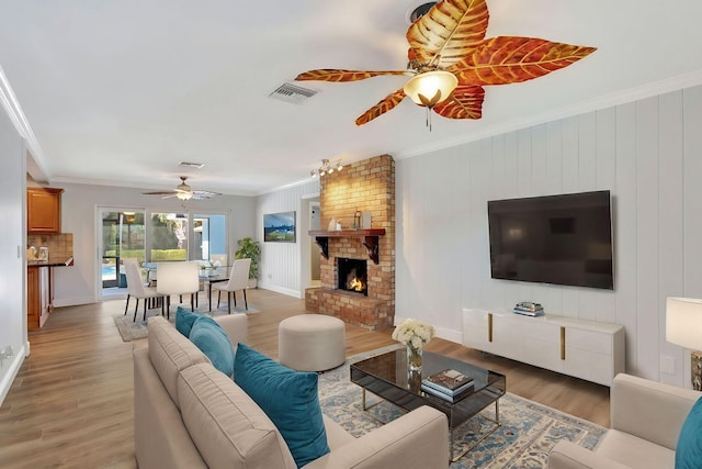 living room featuring hardwood / wood-style floors, a brick fireplace, crown molding, and wood walls