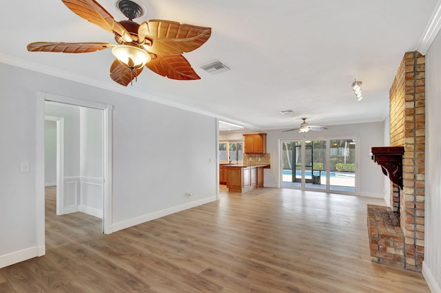 unfurnished living room featuring hardwood / wood-style flooring, ceiling fan, and ornamental molding