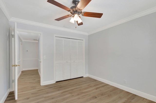 unfurnished bedroom featuring a closet, ceiling fan, crown molding, and light wood-type flooring