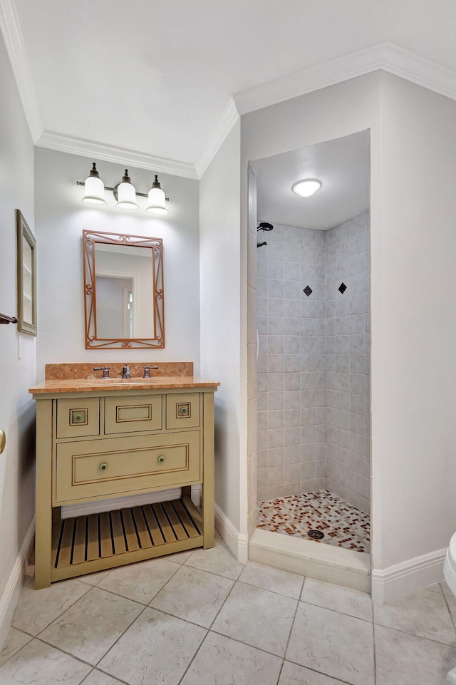 bathroom with a tile shower, tile patterned floors, vanity, and ornamental molding