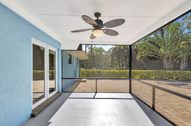 unfurnished sunroom with ceiling fan