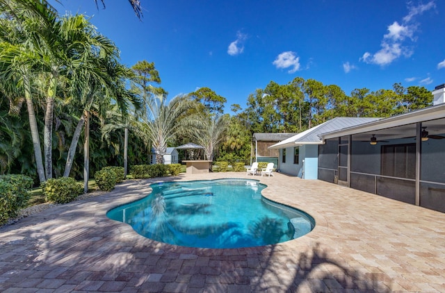 view of swimming pool with a patio, ceiling fan, and a sunroom