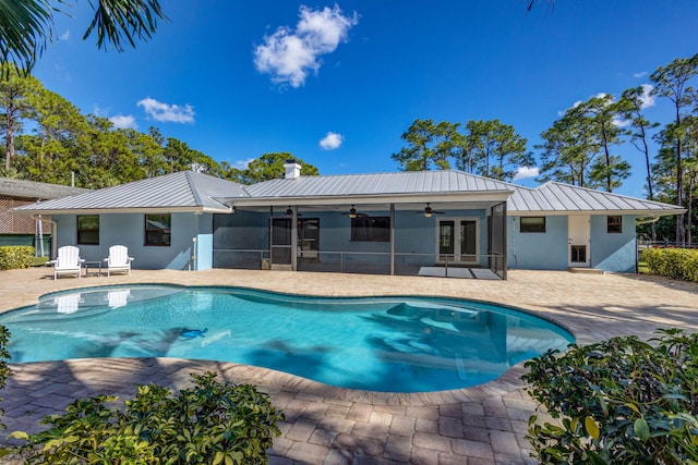 view of swimming pool featuring a patio, ceiling fan, and a sunroom