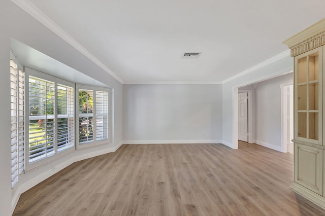 empty room featuring light wood-type flooring and crown molding