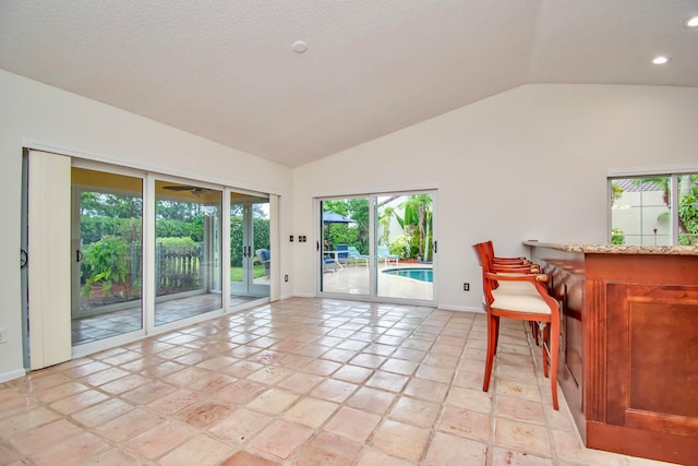 tiled dining area featuring high vaulted ceiling