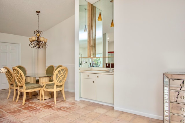 dining space with a chandelier, a textured ceiling, and sink