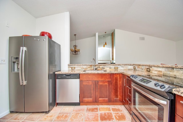 kitchen with light stone counters, stainless steel appliances, sink, pendant lighting, and lofted ceiling