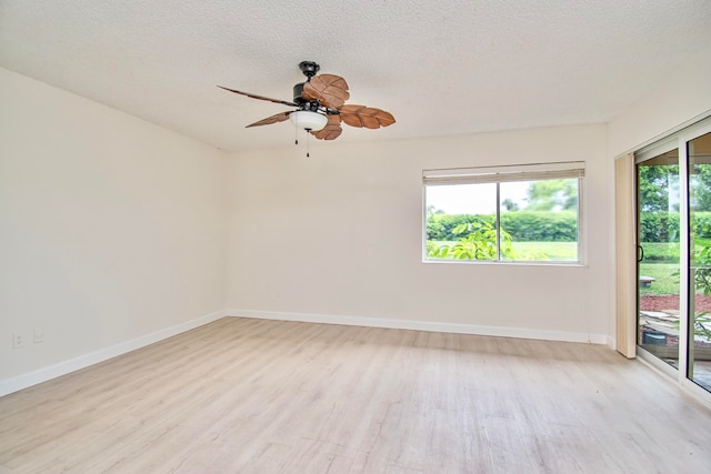 empty room with ceiling fan, a textured ceiling, and light wood-type flooring